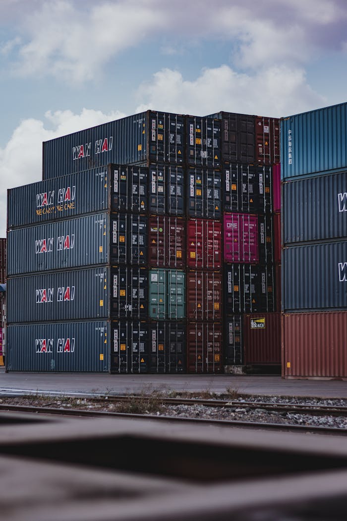 High vertical stack of cargo containers at a port, symbolizing global logistics.